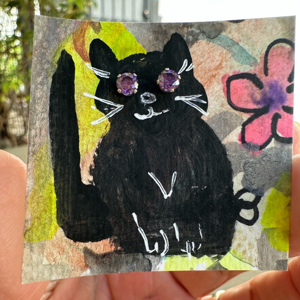 One of a kind, whimsical black cat with purple stud earring eyes.